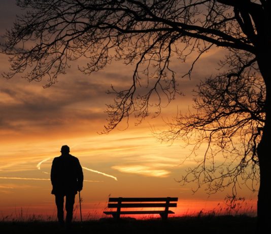 anciano solo ante la puesta de sol