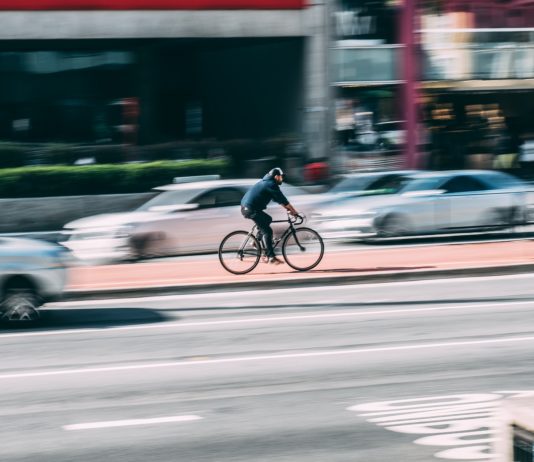 Ciclista enfocado entre coches desenfocados