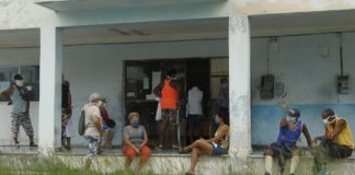 Clientes mantienen la distancia y usan mascarillas protectoras para prevenir el contagio de la enfermedad covid-19 mientras aguardan en el exterior de una farmacia para adquirir medicamentos, en el municipio de 10 de Octubre de La Habana, en Cuba. Foto: Jorge Luis Baños/IPS