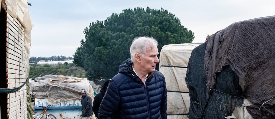 © Bassam Khawaja: El anterior relator especial de la ONU sobre pobreza extrema, Philip Alston, en un campamento de trabajadores migrantes en la ciudad española de Huelva, en Andalucía, España.