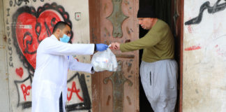 © UNRWA/Khalil Adwan Un trabajador de UNRWA le ayuda con medicamentos a un anciano palestino en la Franja de Gaza