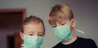 Una niña y un niño con mascarilla