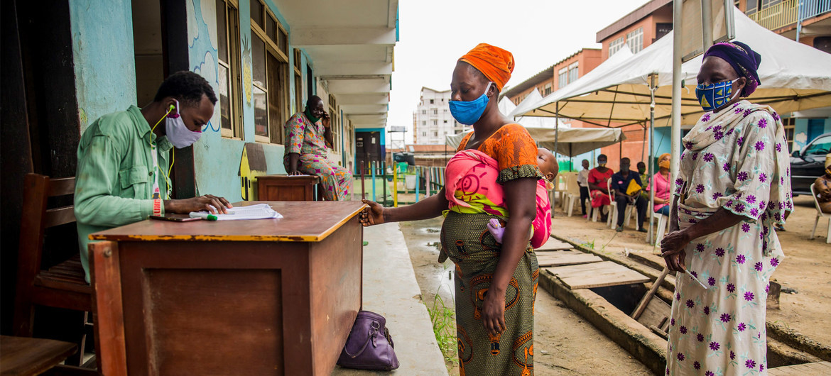 PMA/Damilola Onafuwa Mujeres nigerianas toman vales de alimentos como parte de un programa de apoyo a las familias que luchan contra el confinamiento de la COVID-19