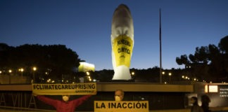 Activistas de Greenpeace han colocado a primera hora de esta mañana una mascarilla gigante (4x5 metros) en una escultura de la plaza de Colón (Madrid) en la que se lee "Pandemia Climática". A su lado, otra pancarta señala "La inacción nos ahoga".