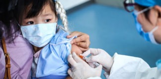 UNICEF/Yuwei: Una niña de 3 años recibe una vacuna en un centro de salud comunitario en Beijing, China.