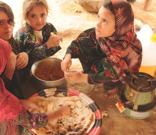 PMA/Abeer Etefa: niñas desplazadas en el campamento de Al-Mazraq en Yemen comparten una simple comida de pan y legumbres preparada por sus madres