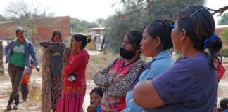 OMS/OPS 2021: Mujeres de una comunidad indígena en Paraguay esperan para recibir su dosis de la vacuna contra el COVID-19.