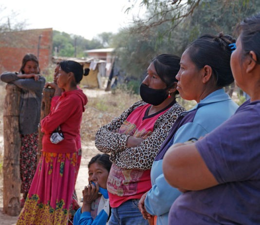 OMS/OPS 2021: Mujeres de una comunidad indígena en Paraguay esperan para recibir su dosis de la vacuna contra el COVID-19.