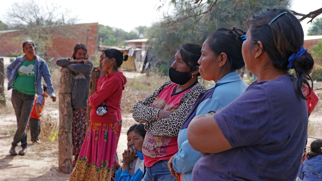 OMS/OPS 2021: Mujeres de una comunidad indígena en Paraguay esperan para recibir su dosis de la vacuna contra el COVID-19.