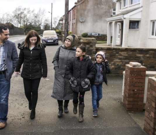Otros tiempos: una refugiada siria y sus dos hijas caminan, un día de 2018, junto a norirlandeses en la ciudad de Armagh, como beneficiarias de un programa de reasentamiento de refugiados que desarrolló Reino Unido. El país ahora prevé deportar a Ruanda a quienes lleguen en condición ilegal. © Paul Wu/Acnur