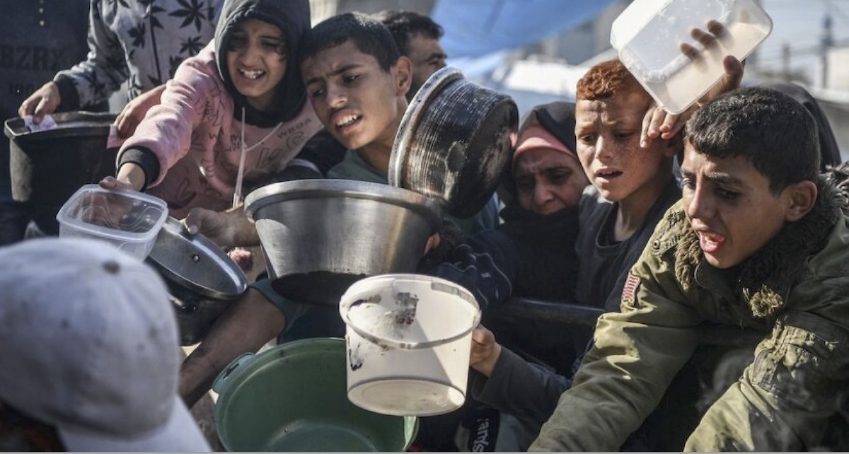 Gaza: niños y jóvenes se esfuerzan por alcanzar una porción de comida que llega con la ayuda humanitaria a la Franja de Gaza. © Abed Zagout / Unicef