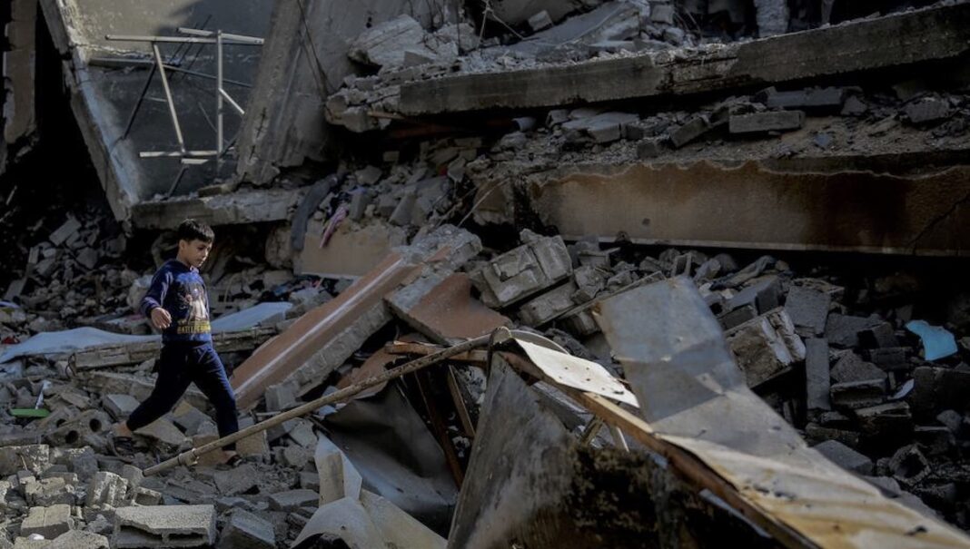 UNICEF/Omar Al-Qattaa Un niño camina sobre los escombros de una casa destruida en la calle Omar Al-Mukhtar Street, en Gaza.