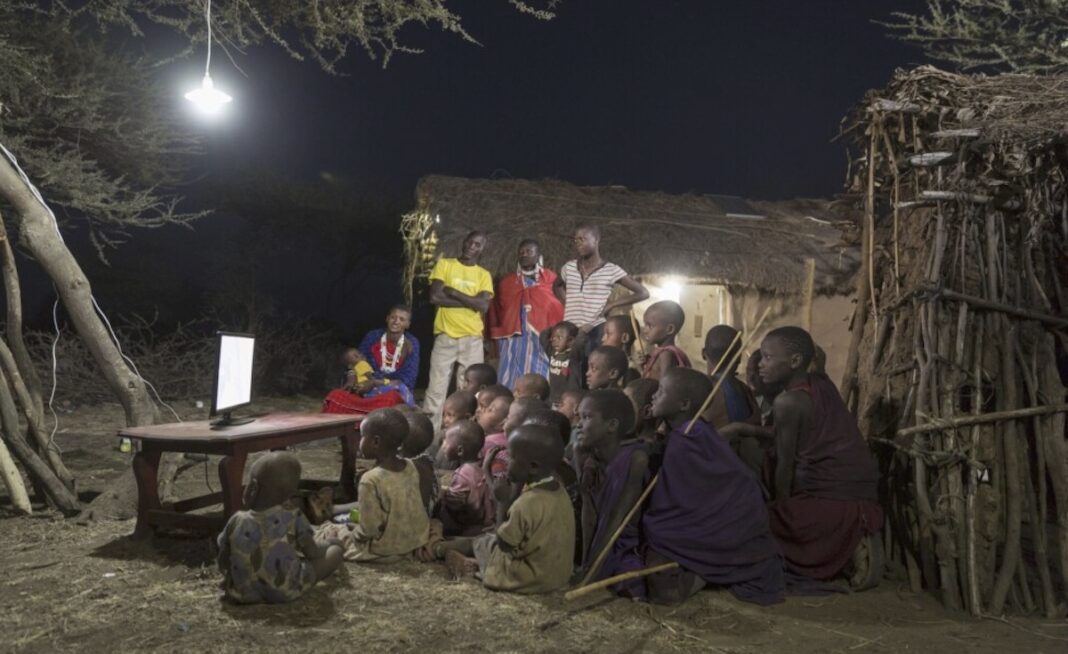 Residentes en una zona rural de Tanzania disfrutan la televisión alimentada con una instalación de energía solar ©Mobisol