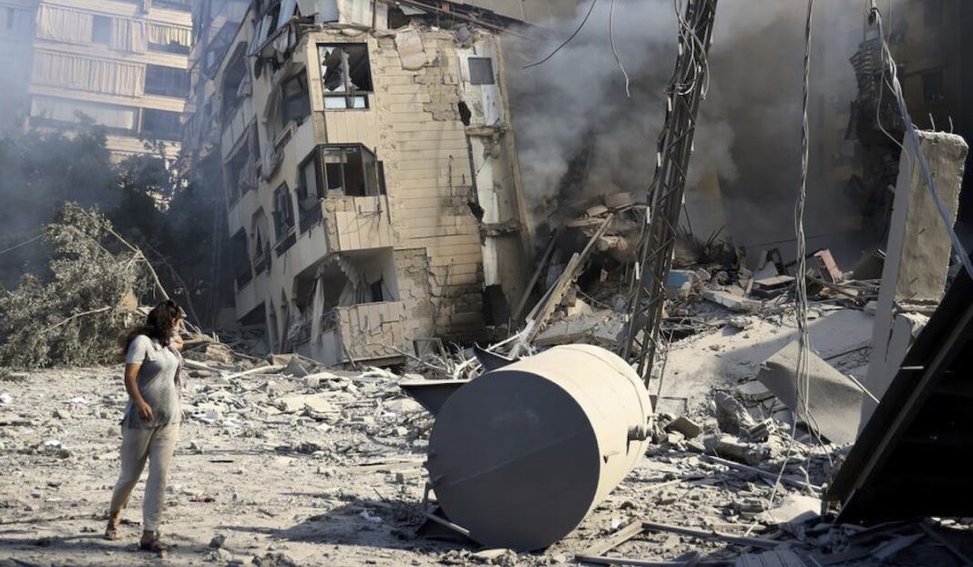 © UNICEF/Dar al Mussawir/Ramzi Haidar Una mujer camina frente a un edificio destruido por los bombardeos israelíes en el sur de Beirut.