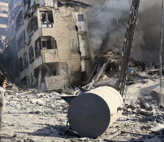 © UNICEF/Dar al Mussawir/Ramzi Haidar Una mujer camina frente a un edificio destruido por los bombardeos israelíes en el sur de Beirut.