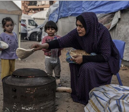 ©UNICEF/Abed Zagout: Una madre prepara comida para sus hijos en el exterior de su casa improvisada en un campo de refugiados de jan Yunis, Gaza