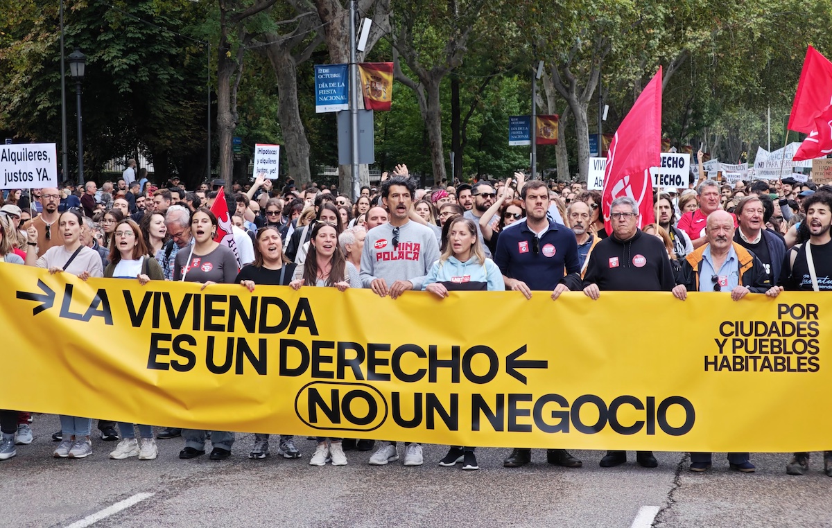 Manifestantes por la vivienda pública y el alquiler asequible en Madrid tras la pancarta de cabeza