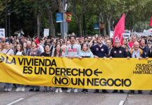 Manifestantes por la vivienda pública y el alquiler asequible en Madrid tras la pancarta de cabeza