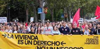 Manifestantes por la vivienda pública y el alquiler asequible en Madrid tras la pancarta de cabeza