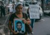 Una mujer muestra una fotografía de su hijo, detenido en una protesta en San Salvador durante el estado de excepción en mayo de 2024 ©Carlos Barrera / HRW