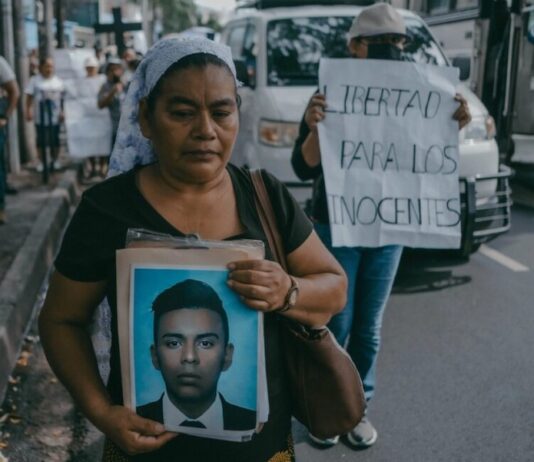 Una mujer muestra una fotografía de su hijo, detenido en una protesta en San Salvador durante el estado de excepción en mayo de 2024 ©Carlos Barrera / HRW