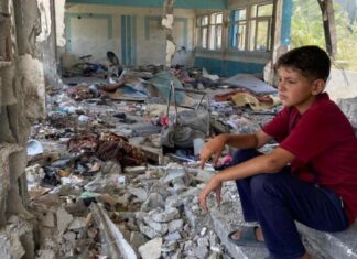 Niño sentado en unos escalones de lo que fue su escuela en Nuseirat, en la Franja de Gaza. @Unrwa