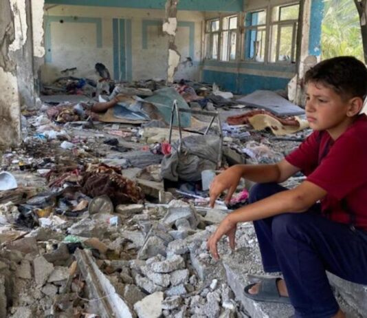 Niño sentado en unos escalones de lo que fue su escuela en Nuseirat, en la Franja de Gaza. @Unrwa