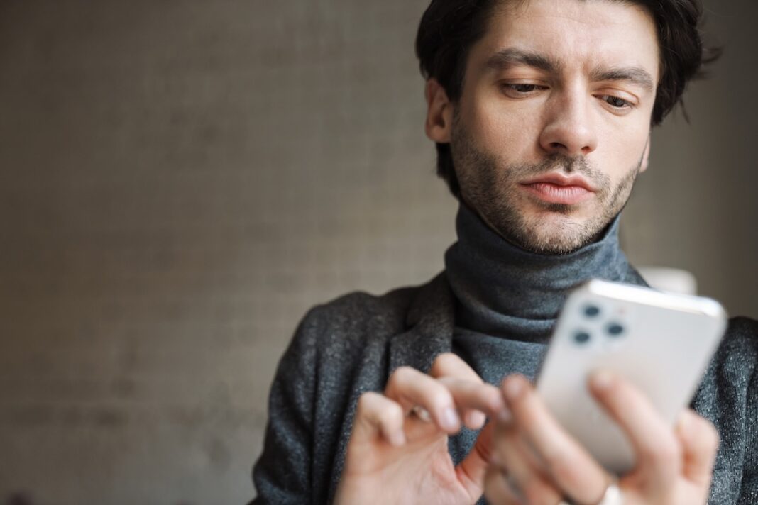 Hombre jjven con teléfono movil ©123RF