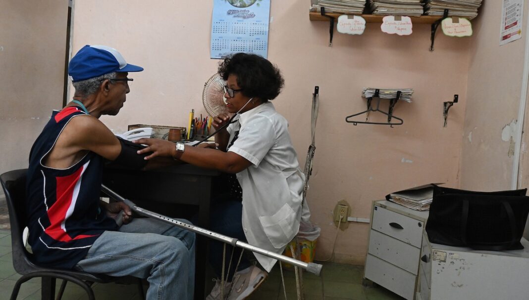 Clínica de Centro Habana ©Jorge Luis Baños : IPS Una doctora mide la presión arterial de un paciente en una clínica de Centro Habana. La atención primaria se ha visto afectada negativamente por el bloqueo petrolero de Estados Unidos a Cuba. Foto: Jorge Luis Baños / IPS