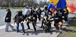 Manifestantes disfrazados de agentes de la ICE y una gran figura inflable de Trump junto al estanque reflectante durante una marcha desde el Cementerio Nacional de Arlington hasta Constitution Gardens como parte de la protesta "No Kings" del 28 de marzo de 2026. © G.EdwardJohnson Wikimedia Commons