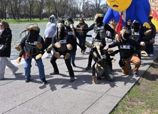 Manifestantes disfrazados de agentes de la ICE y una gran figura inflable de Trump junto al estanque reflectante durante una marcha desde el Cementerio Nacional de Arlington hasta Constitution Gardens como parte de la protesta "No Kings" del 28 de marzo de 2026. © G.EdwardJohnson Wikimedia Commons