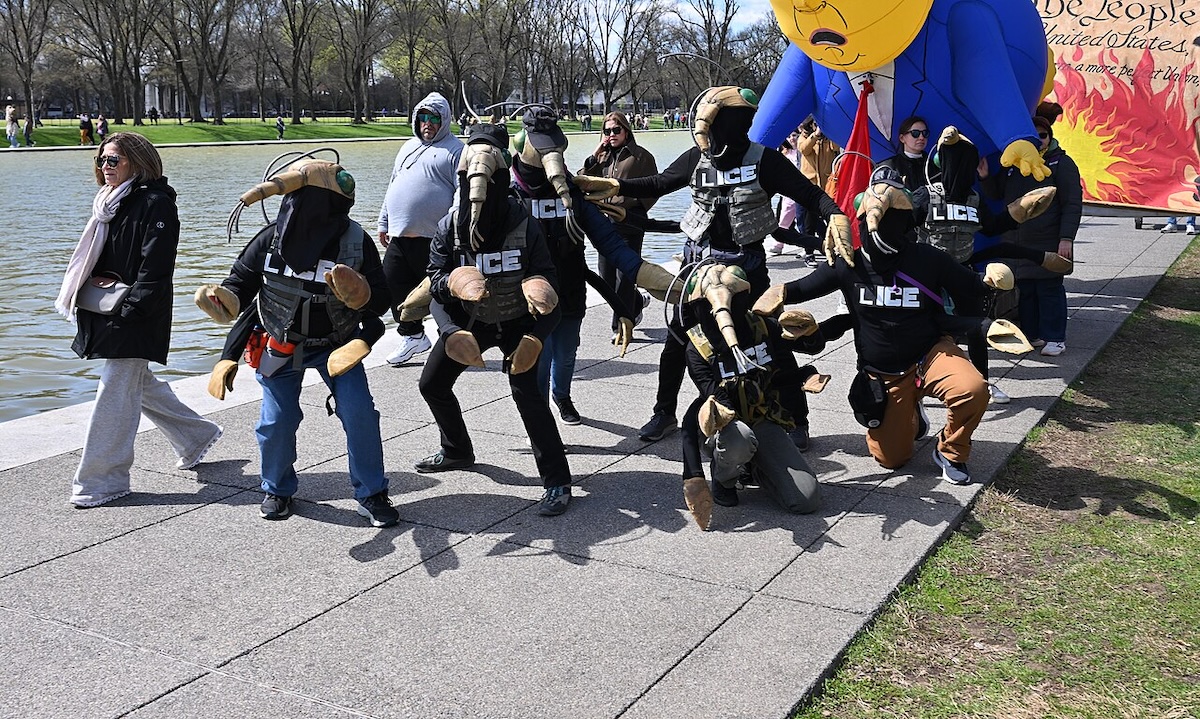 LICE Agents, No Kings, March 28, 2026, Washington, DC Manifestantes disfrazados de agentes de la ICE y una gran figura inflable de Trump junto al estanque reflectante durante una marcha desde el Cementerio Nacional de Arlington hasta Constitution Gardens como parte de la protesta "No Kings" del 28 de marzo de 2026. © G.EdwardJohnson Wikimedia Commons