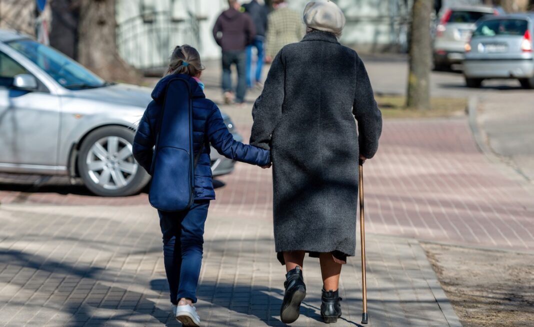 Anciana acompaña al cruzar una calle ©123RF