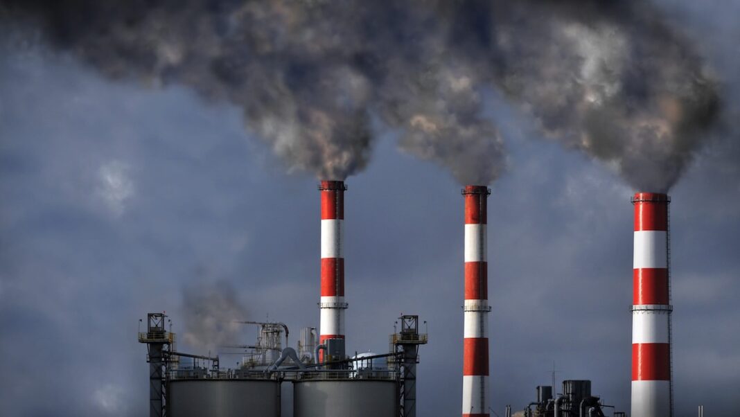 Industrial mokestacks blowing dark smoke into the atmosphere
